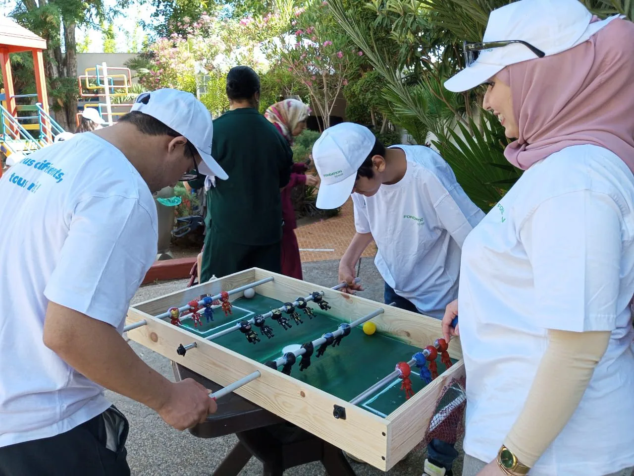 Participants autour d’un baby-foot en plein air