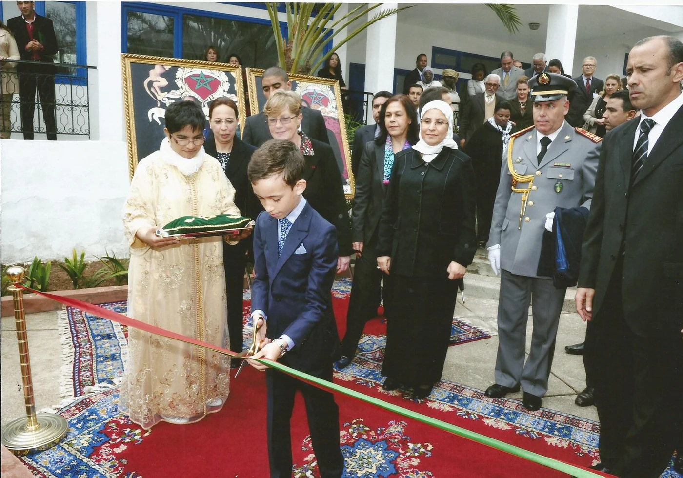 Un jeune participant coupe un ruban lors d’une cérémonie.