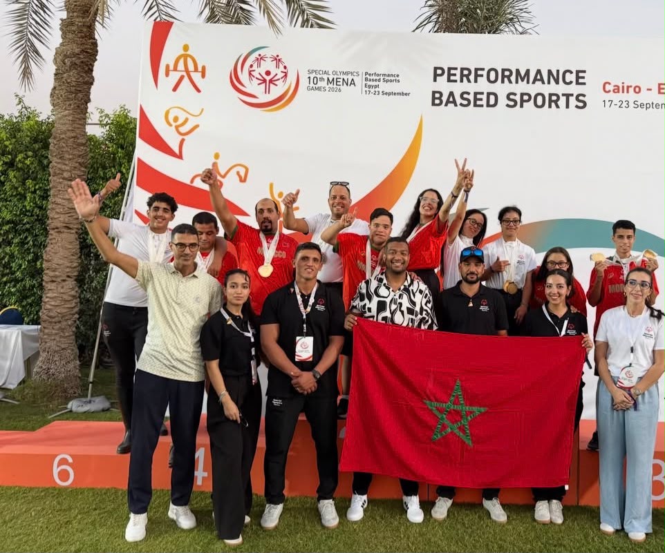 Un groupe pose avec des médailles et le drapeau marocain.